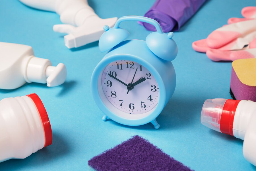 cleaning service concept household chemicals alarm clock blue background